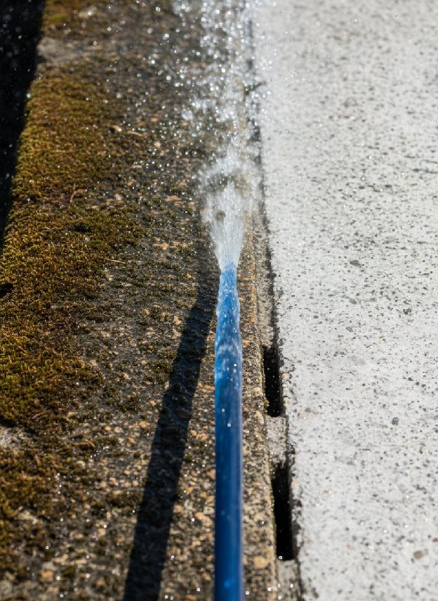 High-pressure water jet cleaning a concrete edge